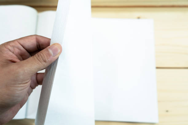 istock man hand open the white empty notebook on the wood table. 1126688254