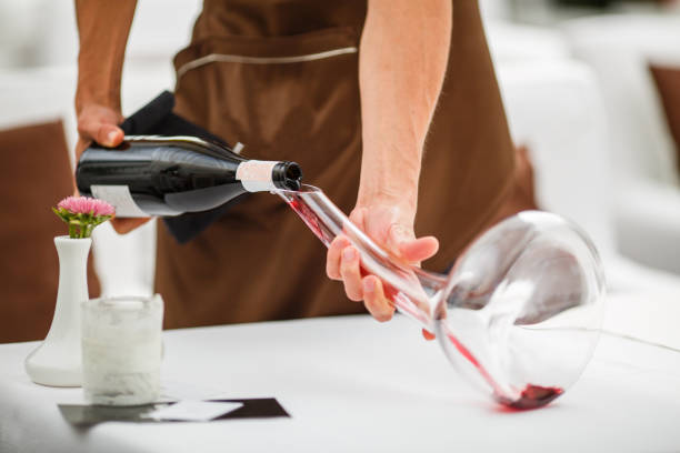 sommelier gießt rotwein in einem glas-dekanter - wine decanter elegance pouring stock-fotos und bilder