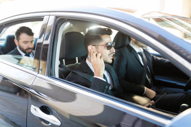 agenti in viaggio con presidente in auto - car driving businessman hands free device foto e immagini stock