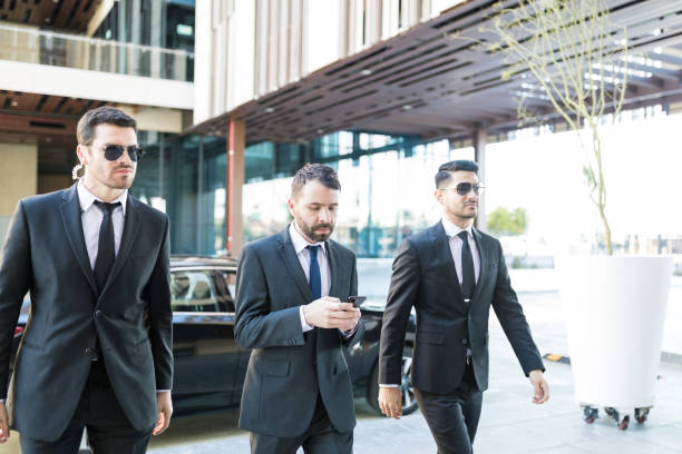 istock Faithful Officers Walking By Wealthy Man 1126701256