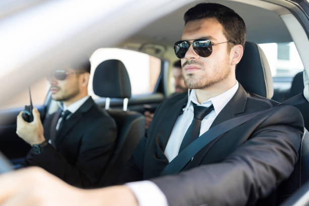 homme en costume, assurer la sécurité à patron pendant le voyage - bodyguard photos et images de collection