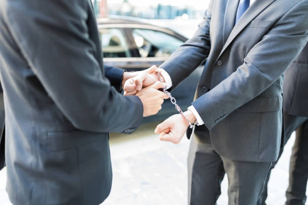 Policeman In Suit Arresting Law Breaker Midsection of undercover agent handcuffing corrupt entrepreneur white collar crime handcuffs stock pictures, royalty-free photos & images