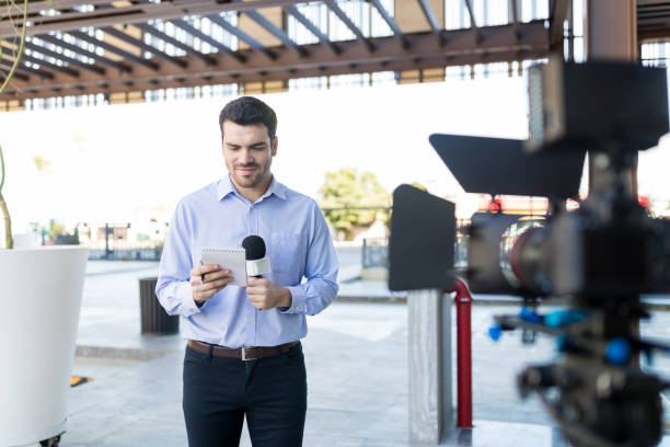 istock TV Reporter Reading Questions At Broadcast 1126703335