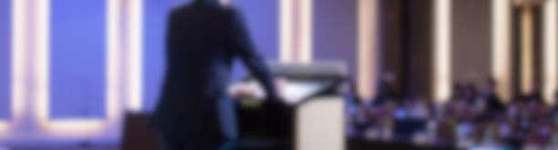 Blurred Speaker with Hands and Arms on Podium at Corporate Conference. Expert Lecture by Business Management at Hall. Leadership Symposium Event for Future Leaders. stock photo