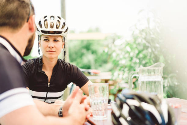 istock Young female cyclist looking at man in yard 1126705458