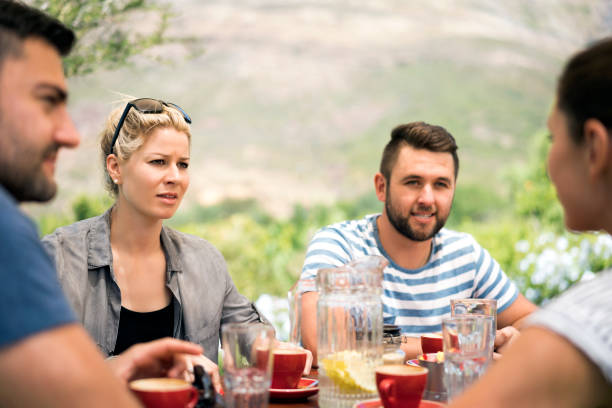 istock Friends talking while sitting at outdoor table 1126705460