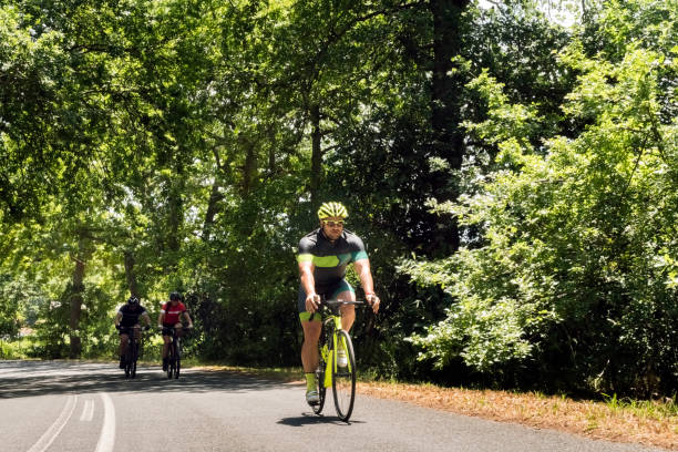 istock Man riding bicycle with friends on country road 1126706714