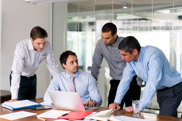 istock Businessman with colleagues discussing over laptop 1126707643
