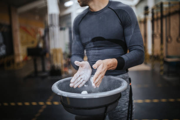 istock Man putting on sports chalk for lifting barbell 1126707967