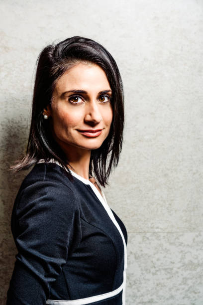 istock Confident businesswoman against gray wall 1126709665