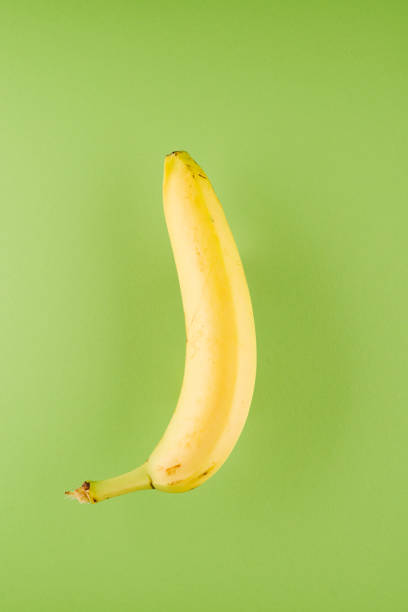 istock Banana in front of green background 1126711170