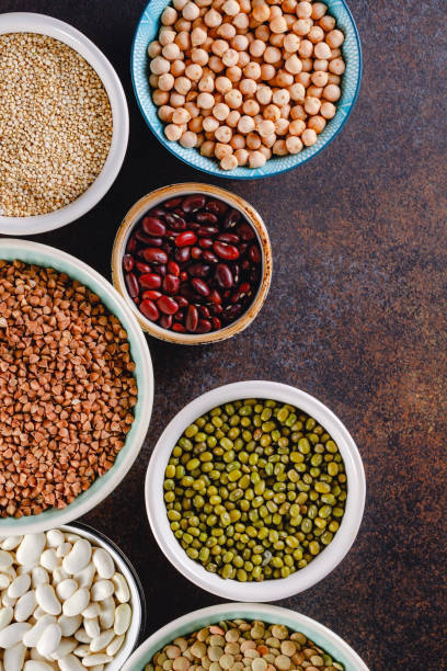 istock Top view on bowls with various raw grains and seeds on a textured dark background. 1126712116