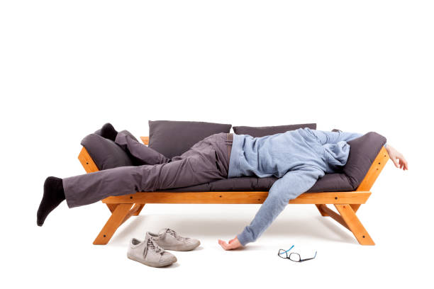 Man lying on sofa with hangover. stock photo