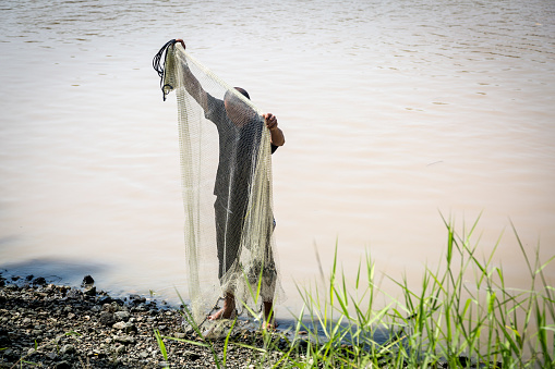 Hazratbal, Srinagar, Jammu and Kashmir, India. October 30, 2022. Man washing laundry on the shore of Dal Lake.