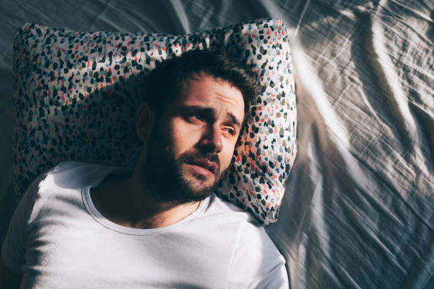 istock Young depressed man crying in bed 1126718668