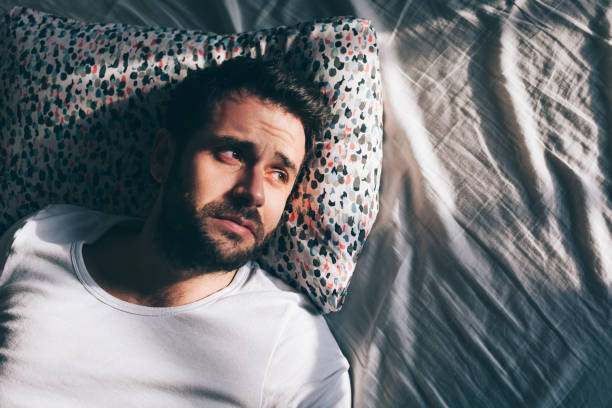 istock Young depressed man crying in bed 1126718671