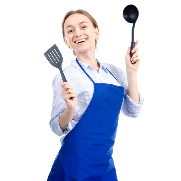 istock Woman in blue apron with kitchen utensils tools in hand 1126720227