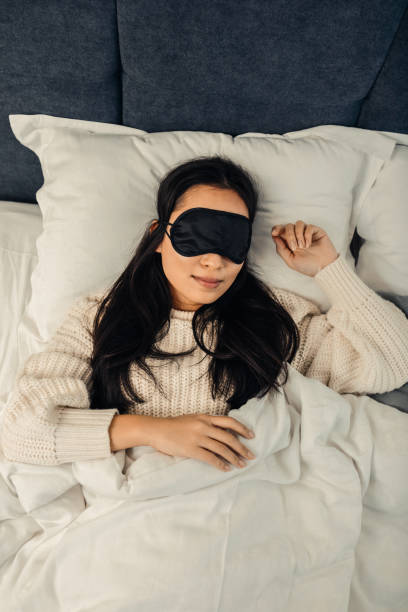 istock Asian woman wearing black sleeping mask lying in bed 1126729440
