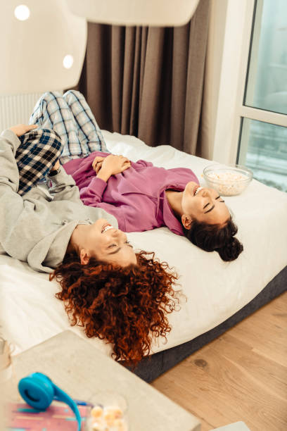 istock Best friends lying on bed after watching movie and eating pop corn 1126729525