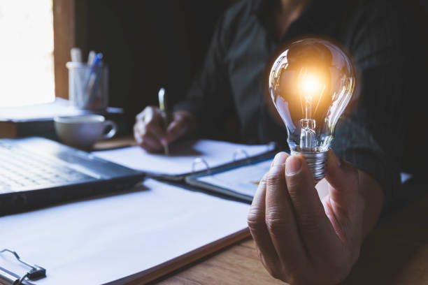istock Hand of male holding a light bulb and writing for idea and creative concept. 1126729730