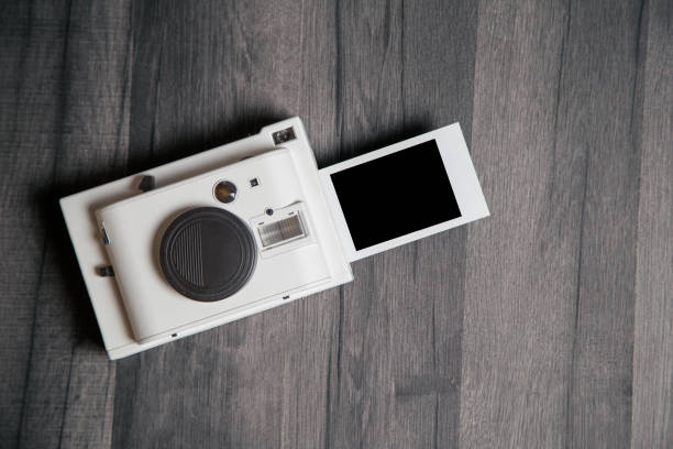 istock Vintage white instant camera with isolated blank photograph 1126734691