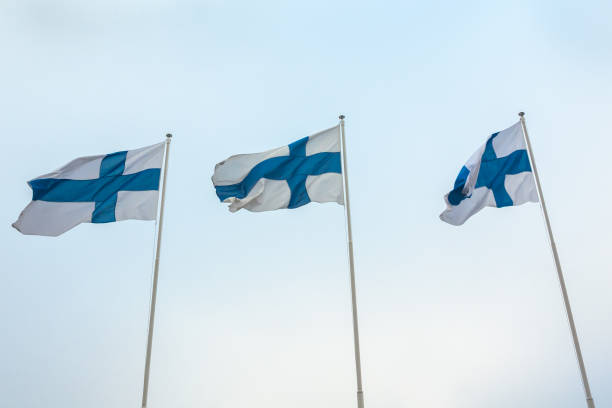 istock Three national flags of Finland on poles at wind and sky background 1126736331