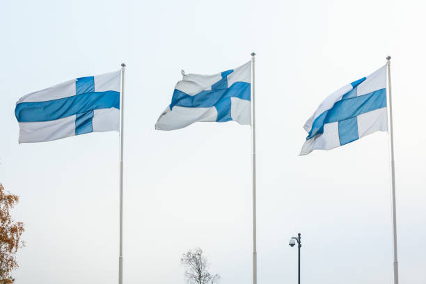istock Three national flags of Finland on poles at wind and sky background 1126736391