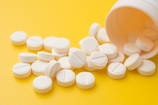 Blanco de las píldoras de aspirina sobre fondo amarillo. photo