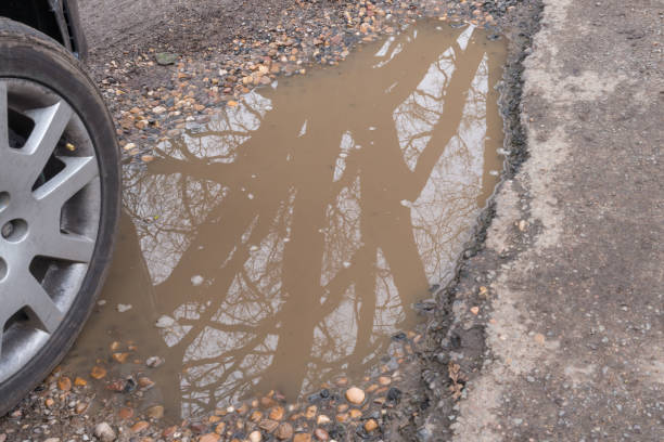 voiture pneus et pot hole ou flaque d’eau - pot hole street car hole photos et images de collection