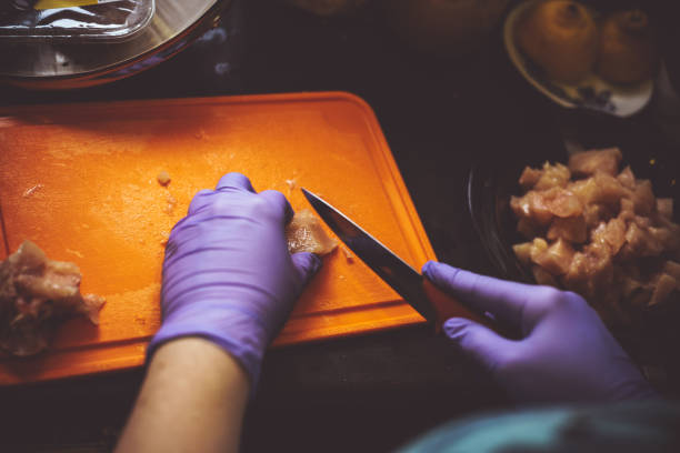 mulher de um frango de corte com uma faca em uma placa na cozinha em casa - lifestyles domestic kitchen human hand furniture - fotografias e filmes do acervo