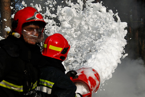 Extinguishing forest fire.Firefighter extinguishes a fire.Extinguishing the fire.  Fill the foam with a fire. Resolute firefighters.