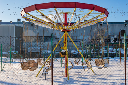 Playground in the winter with a carousel under the snow