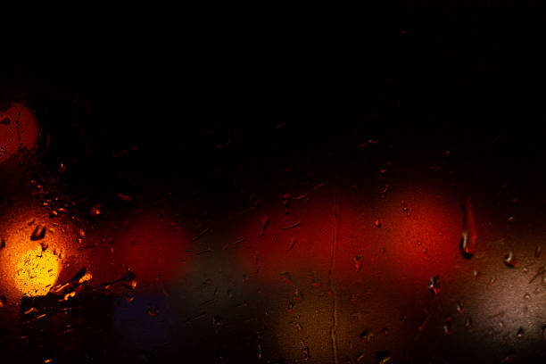 istock Night colorful big city lights through car windshield.Light are defocused and blurred. Focus on windshield. Underexposed photo. 1126745711
