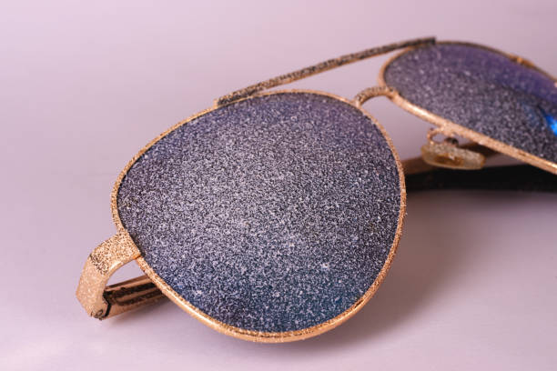 istock Sunglasses with artificial snow on white-purple background close-up view. 1126745730