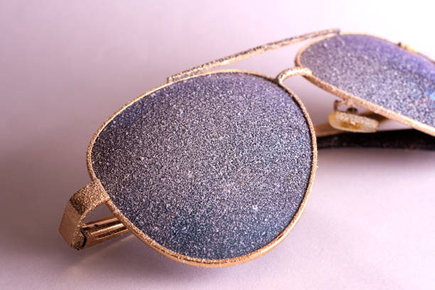 istock Sunglasses with artificial snow on white-purple background close-up view. 1126745732