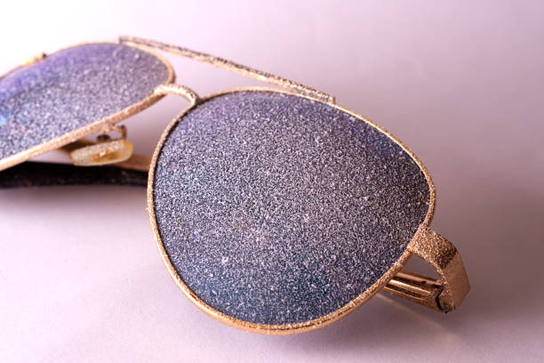 istock Sunglasses with artificial snow on white-purple background close-up view. 1126745733