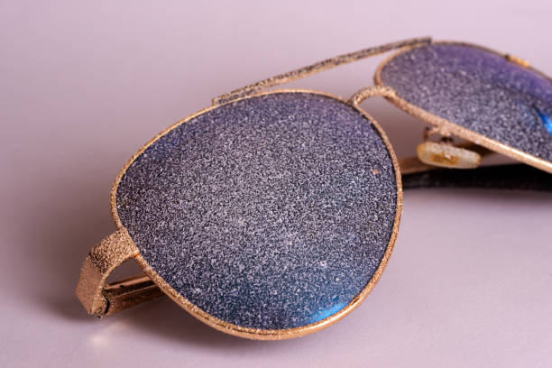 istock Sunglasses with artificial snow on white-purple background close-up view. 1126745735