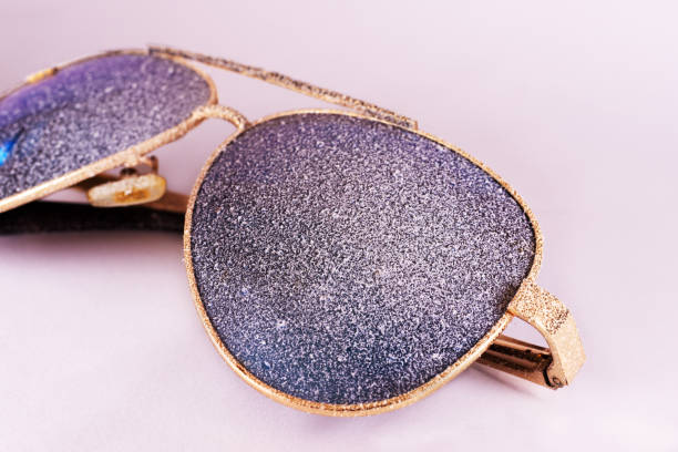 istock Sunglasses with artificial snow on white-purple background close-up view. 1126745736