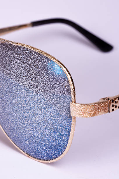 istock Sunglasses with artificial snow on white-purple background close-up view. 1126745743