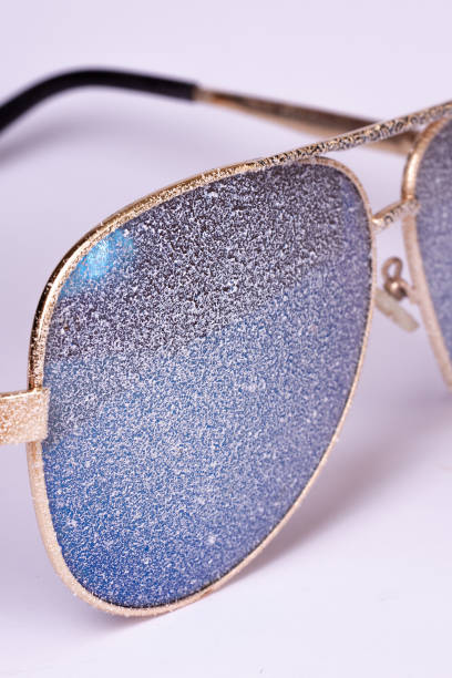 istock Sunglasses with artificial snow on white-purple background close-up view. 1126745749
