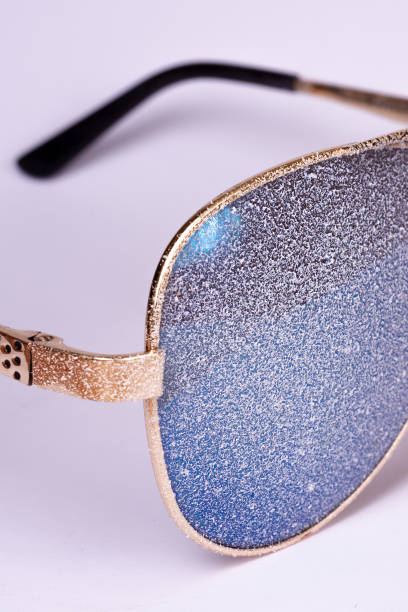 istock Sunglasses with artificial snow on white-purple background close-up view. 1126745752