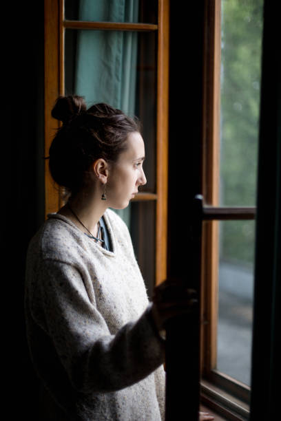 istock Young woman looking out the window 1126748982