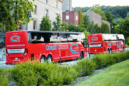 Montreal, Canada - June, 2018: Two red tour bus of Coach Canada company parked on the street in line. Coach canada is a stagecoach group company. Editorial.