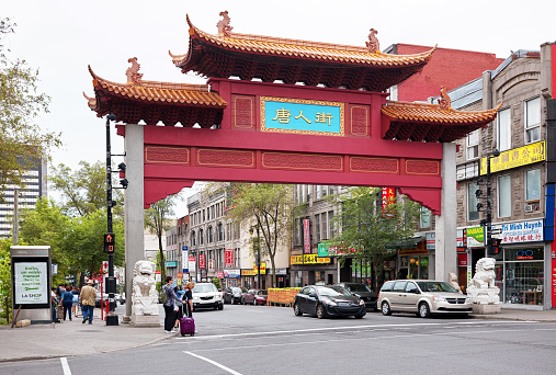 Montreal, Canada - June 2018: The Chinese arch gate, people and traffic at the entrance of China town on st-laurent street in Montreal, Quebec, Canada. Editorial.