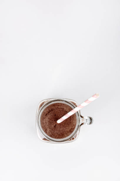 A cup of iced coffee in hand outdoors.
