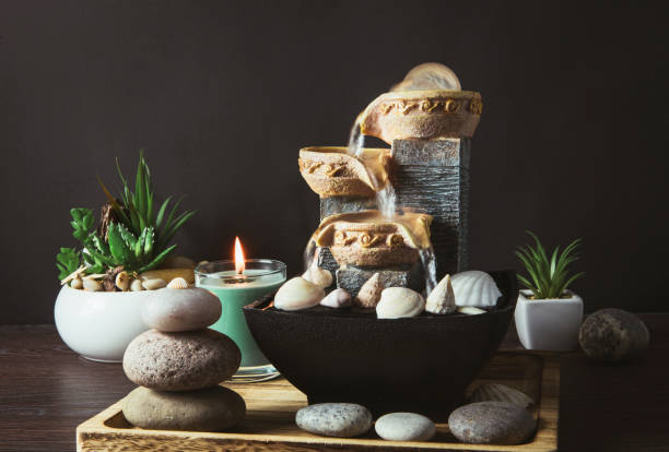 portable indoor fountain for good feng shui in your home concept. portable indoor small tabletop fountain. spiritual mind and soul balance concept. green plants in flower pot on background. - fengshui imagens e fotografias de stock