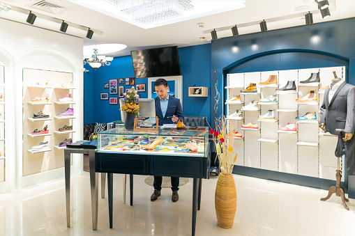Successful small business owner working on new ideas in his luxury shoe store .