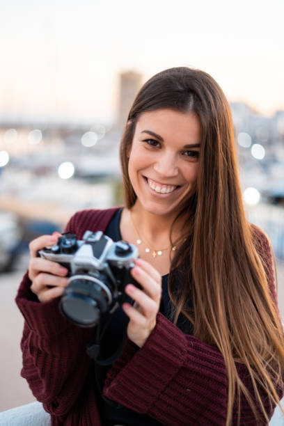 istock Beautiful smiling woman holds a retro camera 1126768596