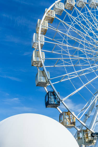 большое колесо обозрения на фоне голубого неба - carnival spinning built structure frame стоковые фото и изображения