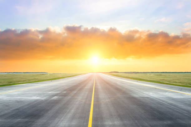 istock Asphalt road with a yellow dividing strip in the evening during sunset. 1126769149